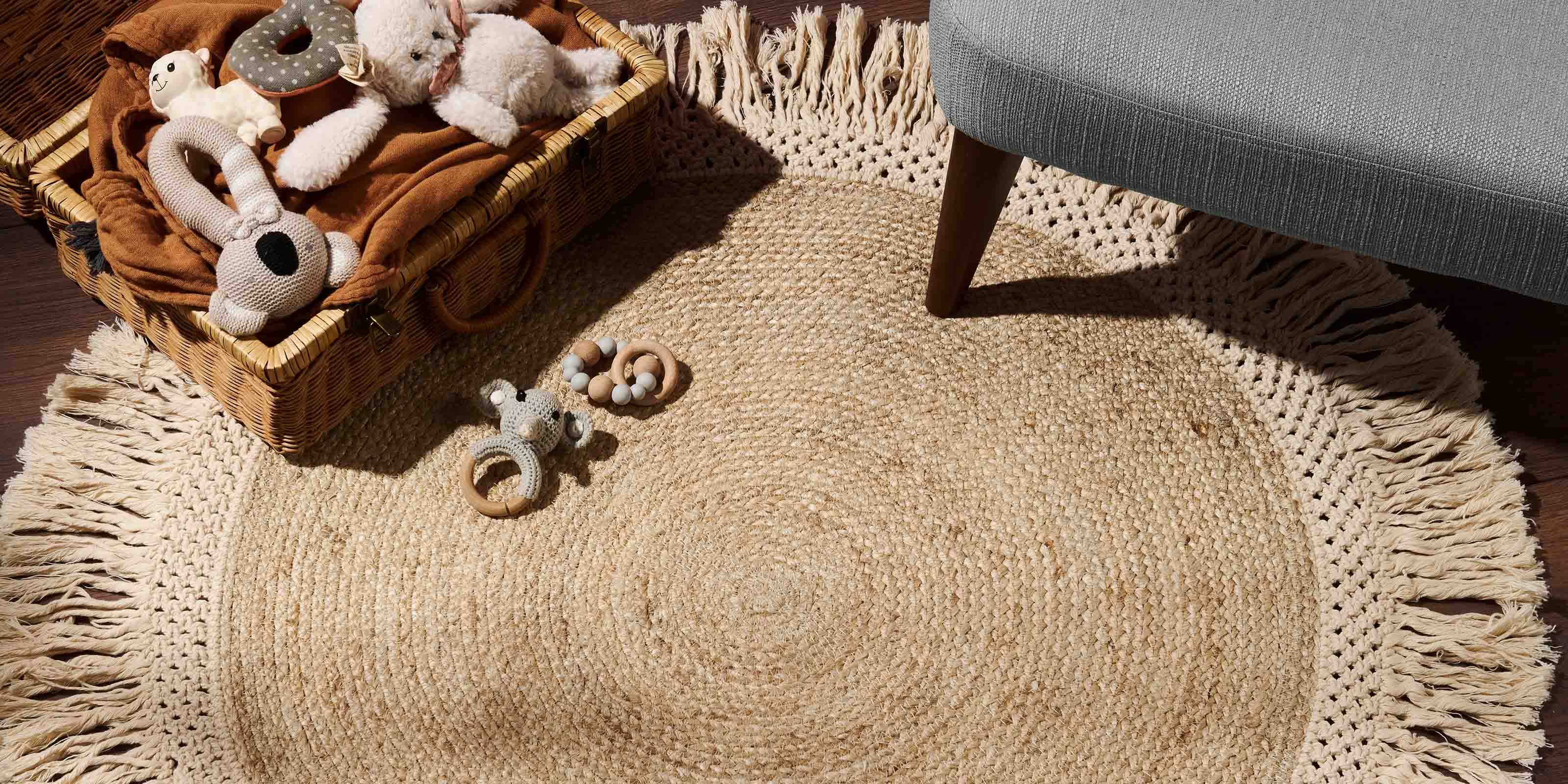 Handmade jute and macrame braided rug with a basket of toys open on top, with a stool