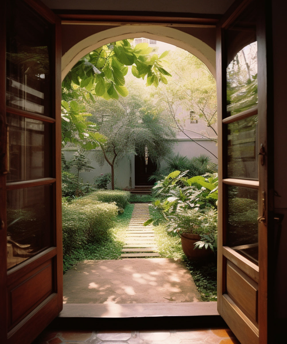 Double doors opening up onto a lush green garden courtyard in Bangladesh