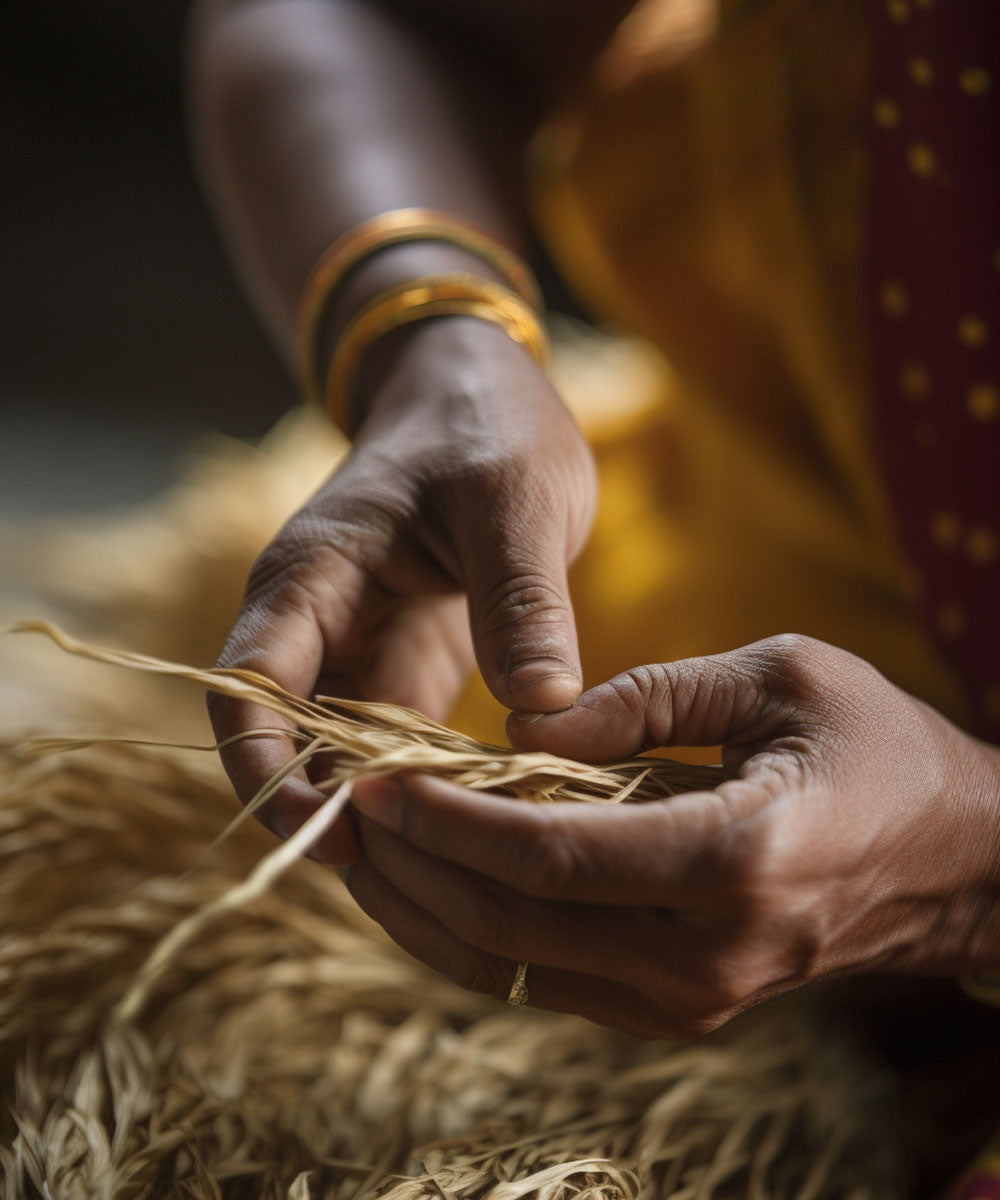 Close up of a Bengali woman's hands working with strands of jute 