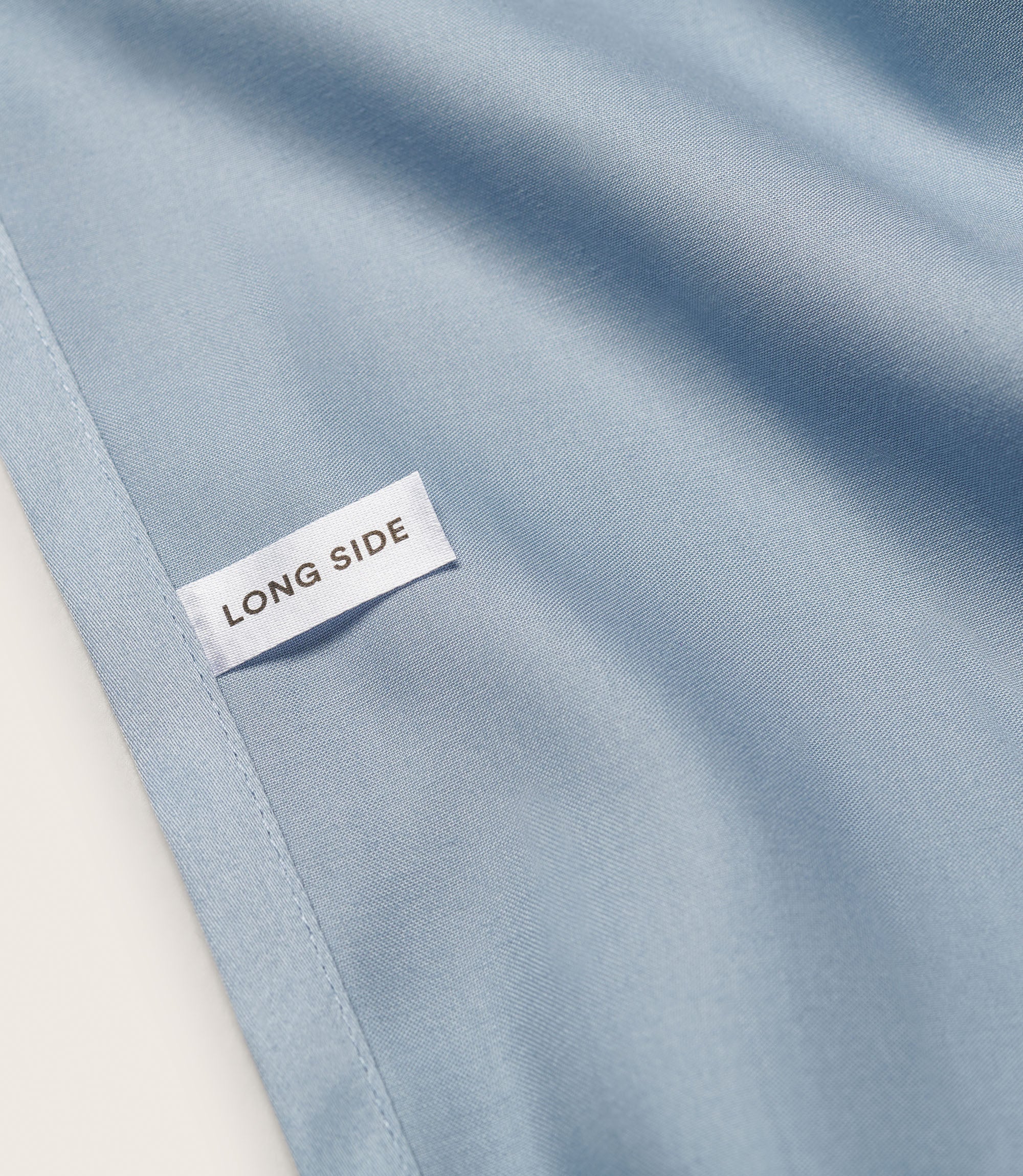 Close up of a fitted sheet with a label for the long side 